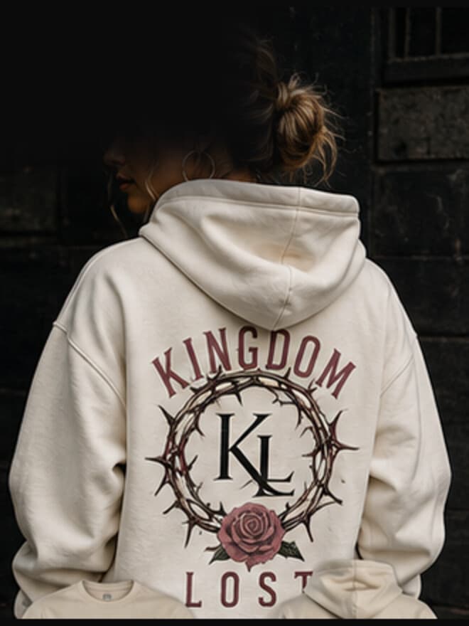 The back of a woman wearing the Thorns and Grace hoodie in bone, the thorn wreath printed across the back panel